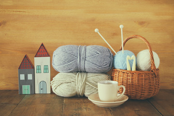 Wall Mural - warm and cozy yarn balls of wool and hot cup of coffee on wooden table.