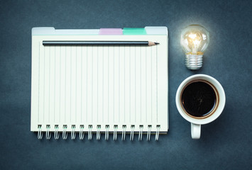 Wall Mural - Light bulb with coffee and notepad on a blue background.