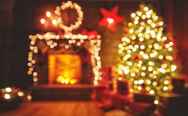 Wall Mural - interior christmas. magic glowing tree, fireplace gifts in dark