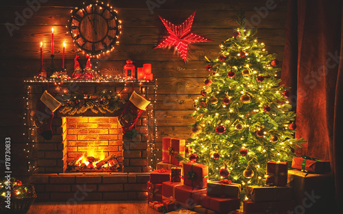 Fotomural interior christmas. magic glowing tree, fireplace gifts in dark