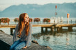 Cute little redheaded girl resting by lake Geneva at sunset, image taken in Lausanne, Switzerland