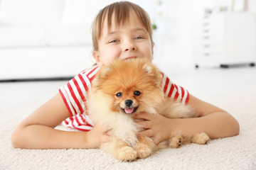 cute girl with little dog on floor at home