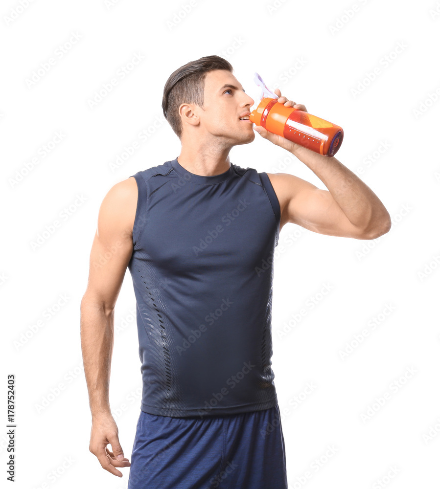 Young man drinking protein shake on white background