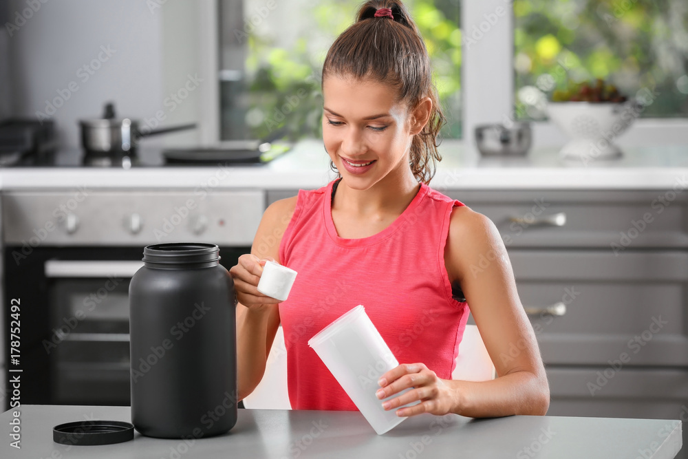 Woman preparing protein shake in kitchen