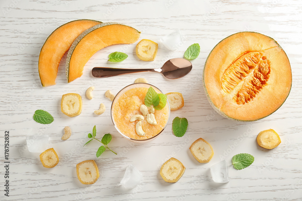 Composition with glass of fresh melon smoothie on table