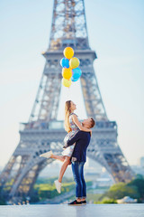 Wall Mural - Couple with colorful balloons near the Eiffel tower