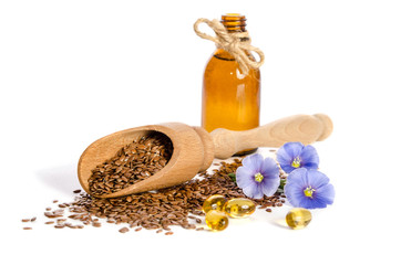 Wall Mural - Flax seeds in the wooden scoop, bottle with oil and  beauty flowers isolated on white background.