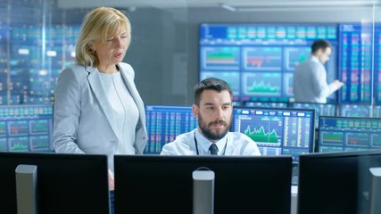Poster - In the Stock Market Firm Chief Executive Talks with Professional Trader. They're Surrounded by Screens with Graphs and Ticker Numbers. Shot on RED EPIC-W 8K Helium Cinema Camera.