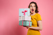 © Drobot Dean - Close-up portrait of shocked pretty girl with bright makeup holding heap of presents, looking aside