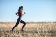 Asian girl in sportswear running across field, morning workout