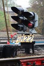 Photo Of A Fragment Of A Railway Track With A Small Traffic Light In Rainy Weather