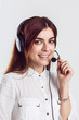 © proimagecontent - Cheerful brunette woman, kindly callcenter operator, wear black white shirt and black headphone set, smiling before white isolated background