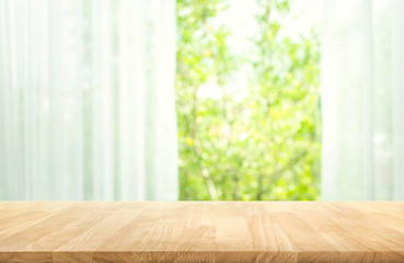 Wall Mural - Empty of wood table top on blur of curtain with window view green from tree garden background.For montage product display or key visual layout