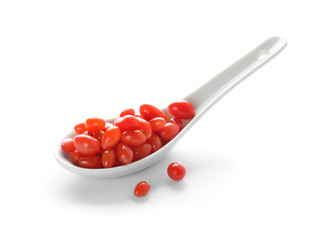 Spoon with goji berries on white background