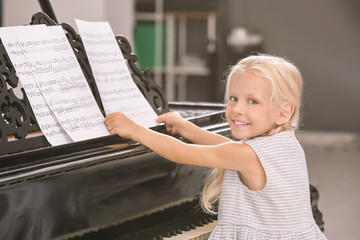 Poster - Little girl playing piano indoors