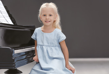 Poster - Little girl sitting near piano indoors