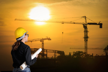 Engineers woman at construction site on background.