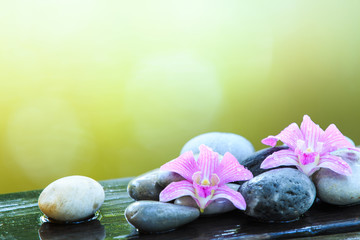 zen stone and pink orchid on the wooden table with copy space for text or product