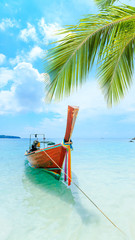 Longtale boat on the white beach at Phuket, Thailand. Phuket is a popular destination famous for its beaches.