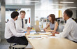 © Monkey Business - Business colleagues brainstorming in an open plan office