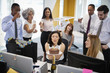 © Monkey Business - Colleagues gathered at woman’s desk to celebrate a birthday