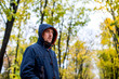 © drotik - man walks in the autumn park. portrait of a man in a hood