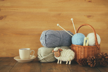 Wall Mural - warm and cozy yarn balls of wool and hot cup of coffee on wooden table.