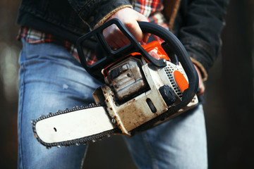 a woodcutter (lumberjack) works with a saw in the forest