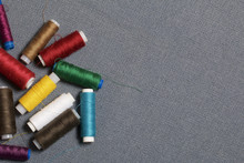 Coils Of Thread Of Different Colors On A Gray Woven Background