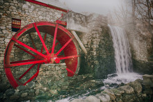 Working Water Mill With A Red Wheel. Old Grist Mill