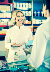 Female pharmacist counseling customer about drugs usage