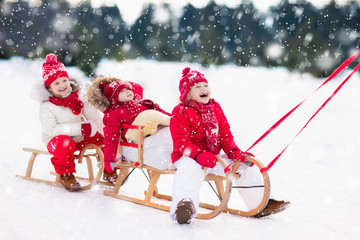 Wall Mural - Kids on sleigh. Children sled. Winter snow fun.