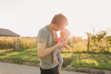 Father and baby daughter outside in the sunset