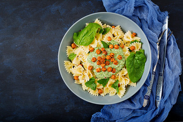 Vegan Farfalle pasta with spinach  sauce with fried chickpeas. Proper nutrition. Sports nutrition. Dietary menu. Flat lay. Top view