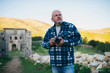 © ysbrandcosijn - Photographer with grey hair in ghost town Old Perithia, Corfu, Greece.