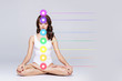 © Acronym - Woman meditating in lotus position. Colored chakra lights over her body. Yoga, zen, Buddhism, recovery and wellbeing concept.