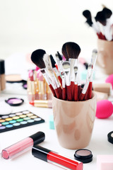 Different makeup cosmetics on white table