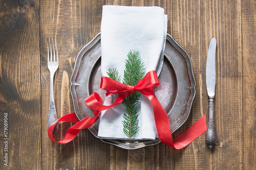 Plakat Boże Narodzenie ustawienie stołu z candy cane i czerwoną wstążką jako wystrój, vintage dishware, sztućce i dekoracje na desce. Widok z góry.