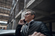 © Bogdan - Close-up. A young handsome man talking on the phone. He smiles. Standing at the car parking