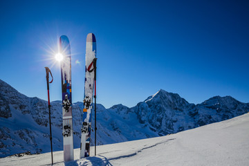 Fototapete - Ski in winter season, mountains and ski touring backcountry equipments on the top of snowy mountains in sunny day. South Tirol, Solda in Italy.