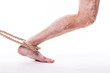 rope holding human leg ailing varicose veins of the lower extremities and venous thrombophlebitis and on a white background, with depth of field Photo