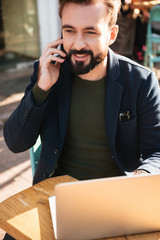 Wall Mural - Portrait of a smiling handsome man working on laptop