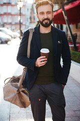 Wall Mural - Portrait of a smiling bearded man drinking coffee