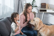 © LIGHTFIELD STUDIOS - mother and daughter petting dog