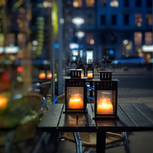 Lanterns With Candles On A Table On Christmas Fair. Night In A Big City.