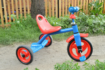 Tricycle kids bike Bicycle blue and red new is on the road in the garden to entertain children