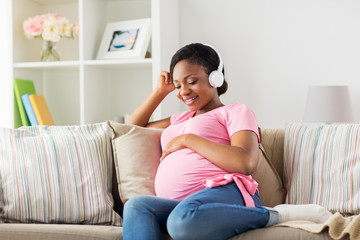 Poster - pregnant woman in headphones at home