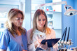 © Bojan - Female nurse and dentist reading patient's dental results from clipboard in dentist's office.