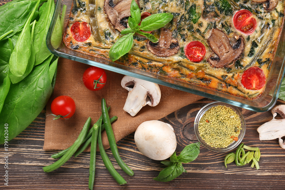 Glass baking dish with delicious spinach frittata on fabric