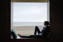 Youth Sitting In A Window And Looking At The Sea